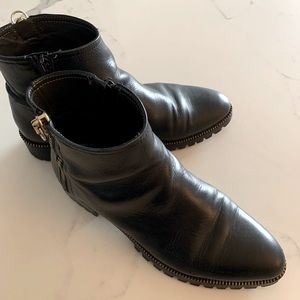 Italian leather ankle boots with gold zipper detail, rugged tread.